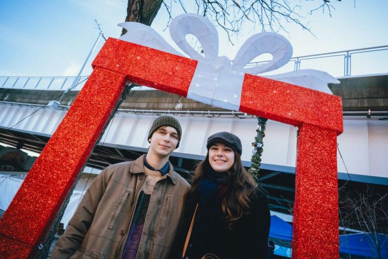 Two people in front of a christmas present display