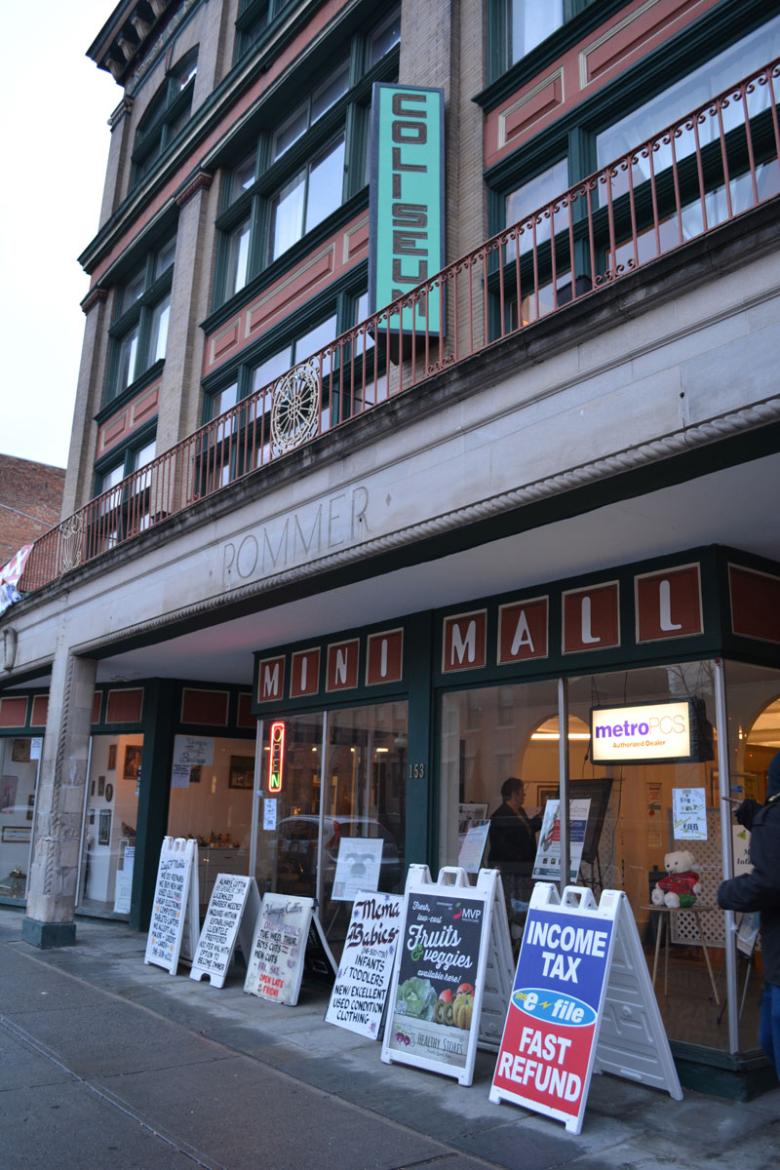 Coliseum mall in downtown albany, sandwich board signs line the sidewalk advertising the deals and offerings found inside. 