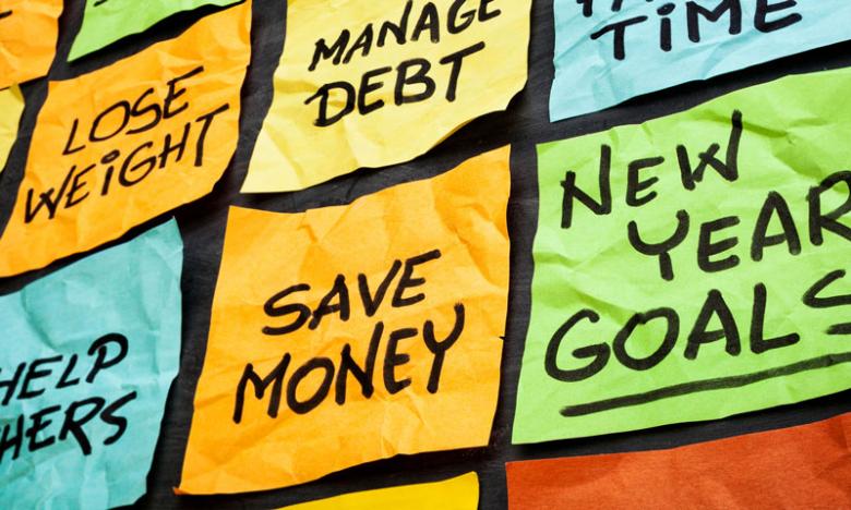 image of sticky notes with popular new years resolutions written in sharpie, such as save money and lose weight