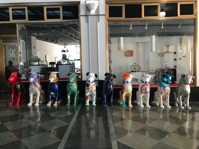 A row of painted nipper art sculptures sit facing the camera