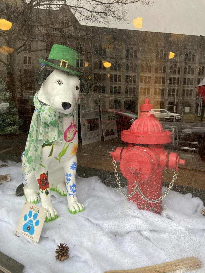 Dog Statue in a St. patrick day hat next to fire hydrant